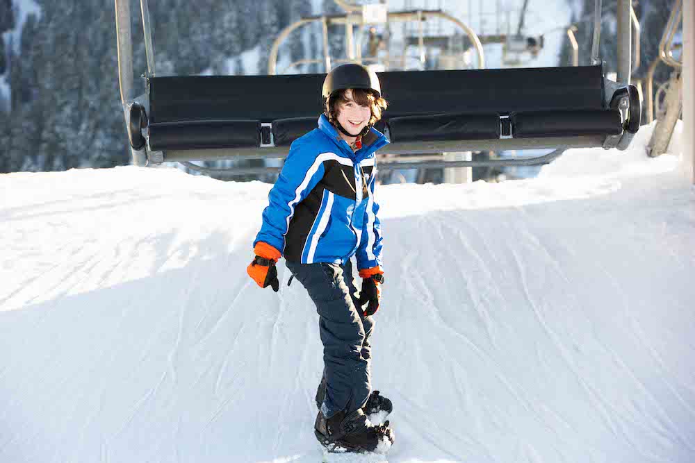 shutterstock_114546880 kind getting of a chair on his snowboard